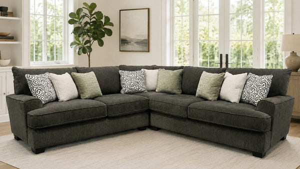 Gray sectional sofa with patterned cushions in a living room setting.