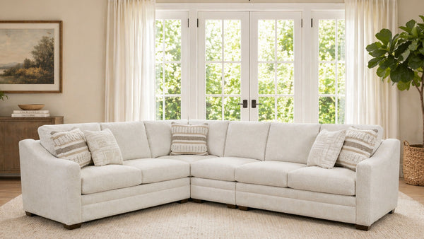 White sectional sofa in a living room with large windows and decorative elements.