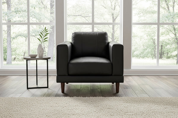 A black leather upholstered chair with wooden tapered legs, featuring a high backrest and armrests.