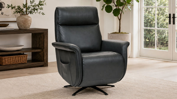 Un sillón giratorio reclinable de cuero negro con un bolsillo lateral, que se muestra en un salón luminoso y moderno con una mesa consola de madera y plantas en macetas.