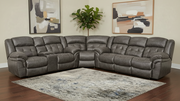 Sofá modular gris en una sala de estar decorada con arte abstracto y una planta.