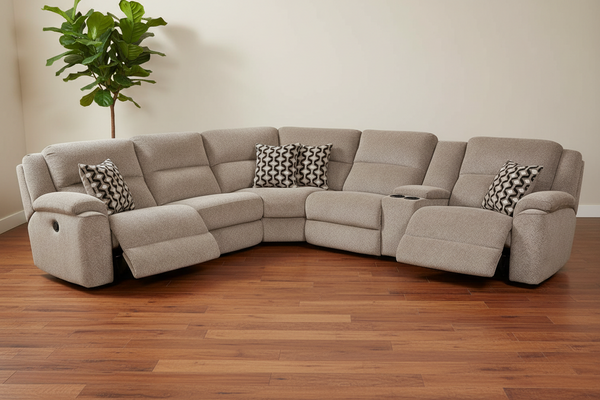 Sofá modular gris con cojines estampados sobre un suelo de madera.