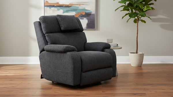 Gray recliner chair in a living room setting with a plant and wall art.