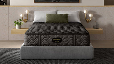 Gray mattress on a bed in a modern bedroom with abstract art and shelves.