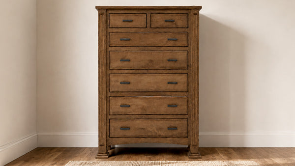 A rustic brown wooden chest of drawers with six drawers and dark metal handles, standing against a beige wall on a wood floor.