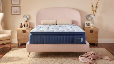 King size Stearns & Foster Estate Firm Pillowtop Mattress on a bed in a bedroom setting with decorative pillows, a nightstand, and a lamp.