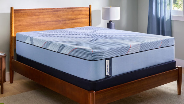 Colchón azul sobre un somier de madera en un dormitorio