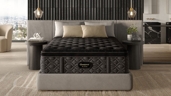 Un colchón Beautyrest Black Series 3 Medium Pillowtop de tamaño king, expuesto en un lujoso dormitorio, en el que destaca su diseño con motivos en negro y dorado.
