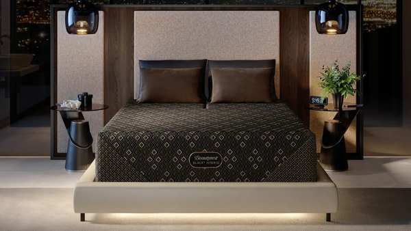 Dormitorio moderno con cama con colchón de marca, mesitas de noche y elementos decorativos.