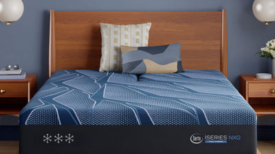 Blue mattress with brand logo on a wooden bed in a bedroom setting