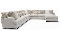 Beige sectional sofa with patterned cushions on a white background