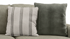 Two textured pillows on a sofa with a neutral background