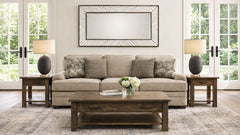 Living room with beige sofa, wooden coffee table, and side tables.