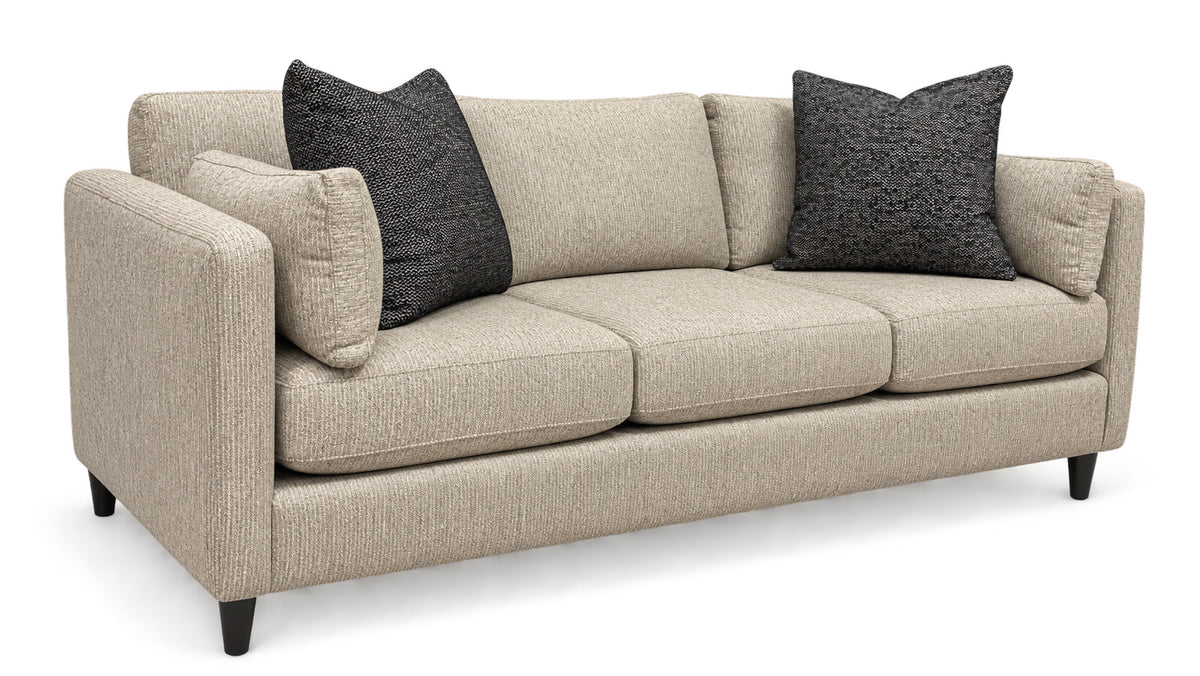 A three-seat upholstered sofa in a light beige textured fabric, styled with two dark gray textured throw pillows and black legs, shown on a white background.