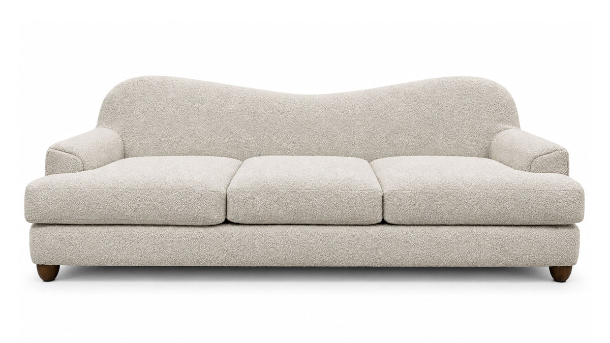 A modern three-seat sofa upholstered in a textured cream bouclé fabric, featuring a curved backrest and dark wooden legs, shown against a plain white background.