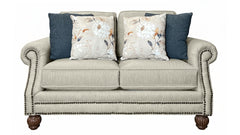 Sofá beige con cojines decorativos sobre un fondo blanco