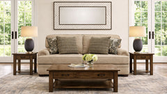 Living room with beige sofa, wooden coffee table, and side tables with decorative items.