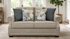 Beige sofa with decorative pillows in a living room setting