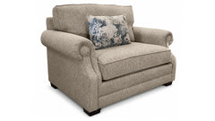 Sillón beige con un cojín floral sobre fondo blanco