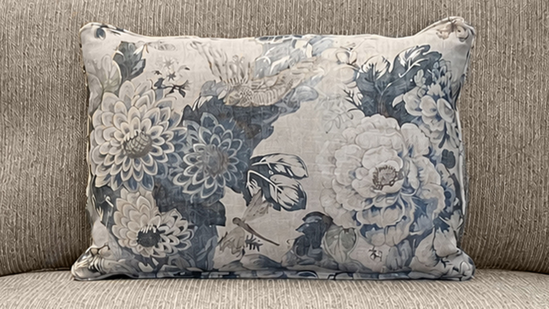 Cojín con estampado floral sobre un sofá beige