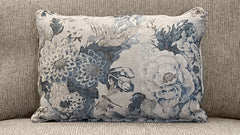 Cojín con estampado floral sobre un sofá beige