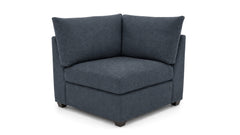 A dark blue upholstered corner armchair with a low boxy seat and two back cushions, shown on a plain white background.