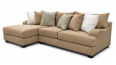 A beige fabric sectional sofa with a left-facing chaise lounge, styled with multiple throw pillows in beige, textured gray, and white, shown against a plain white background.