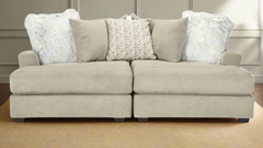 Beige sectional sofa with decorative pillows on a carpeted floor.