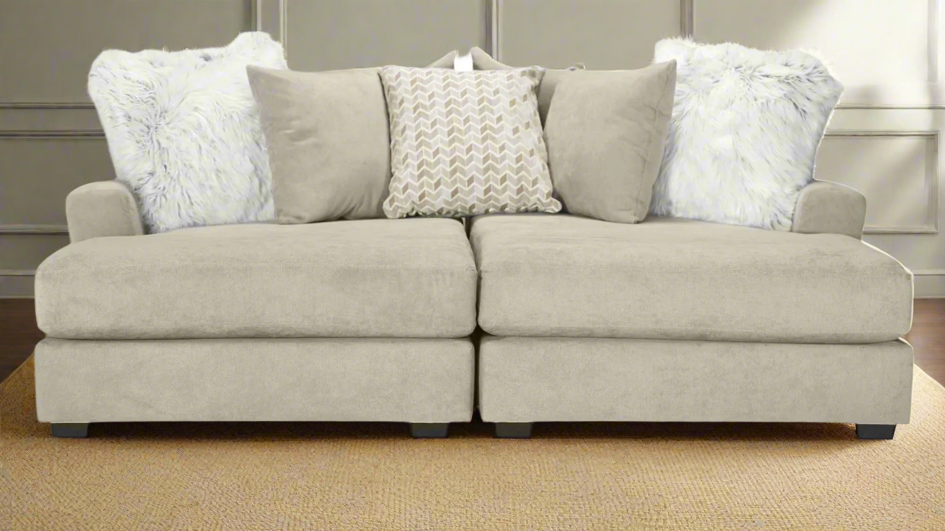 Beige sectional sofa with decorative pillows on a carpeted floor.