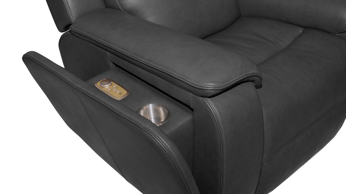 Close-up of a dark gray leather recliner chair showing the extended footrest with a small control panel and a cup holder, on a white background.