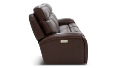 A dark brown leather reclining loveseat with a small metallic brand plaque on the side, shown from a three-quarters angle against a white background.