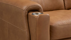 Close-up of a tan leather sofa arm with a curved rolled edge and a stainless steel cup holder inset on the side.