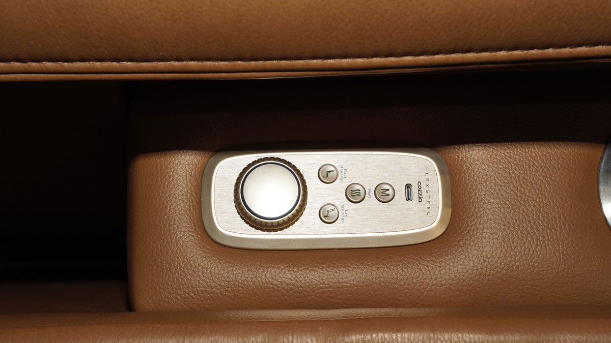Close-up of a beige leather interior with a silver control panel featuring a rotary dial and buttons.