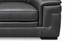 Close-up of a dark gray leather sofa armrest showing the texture, stitching, and corner detail against a white background.