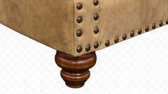 Close-up of a brown upholstered chair with wooden legs on a white background