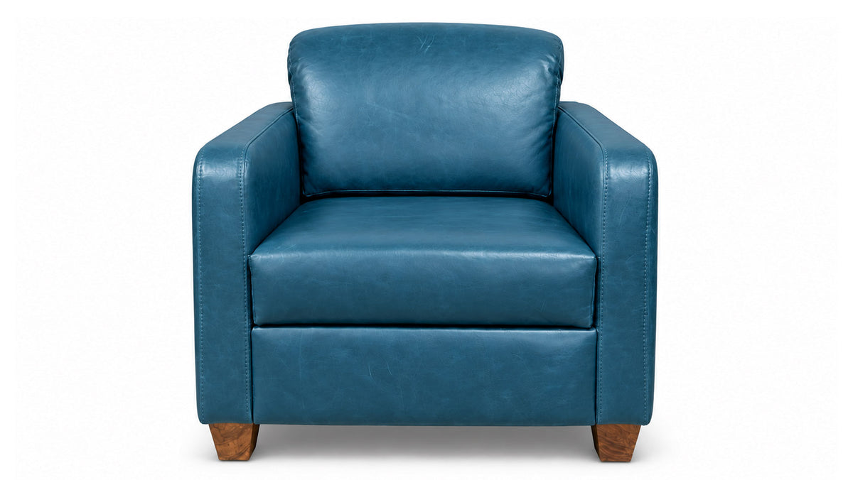 Un sillón de cuero azul con respaldo cuadrado y patas de madera, fotografiado sobre un fondo blanco liso.