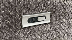 Metallic USB and power outlet panel on a textured gray surface