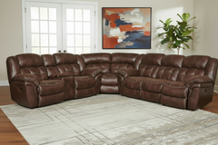 Brown leather sectional sofa in a living room setting with a painting and plant in the background.