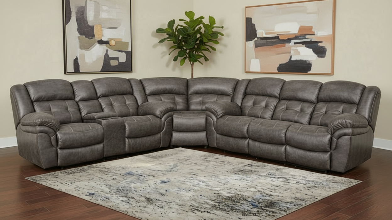 Gray sectional sofa in a living room setting with abstract art and a plant.