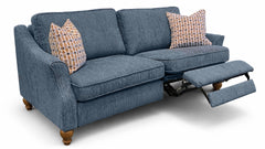 A blue upholstered reclining sofa with two patterned accent pillows and an extended footrest, shown on a clean white background.