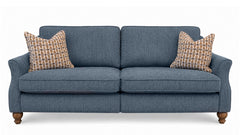 A two-seater loveseat sofa upholstered in textured slate blue fabric, featuring two patterned throw pillows and turned wood legs, shown against a plain white background.