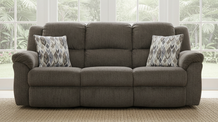 Gray sofa with patterned cushions in a room with large windows.