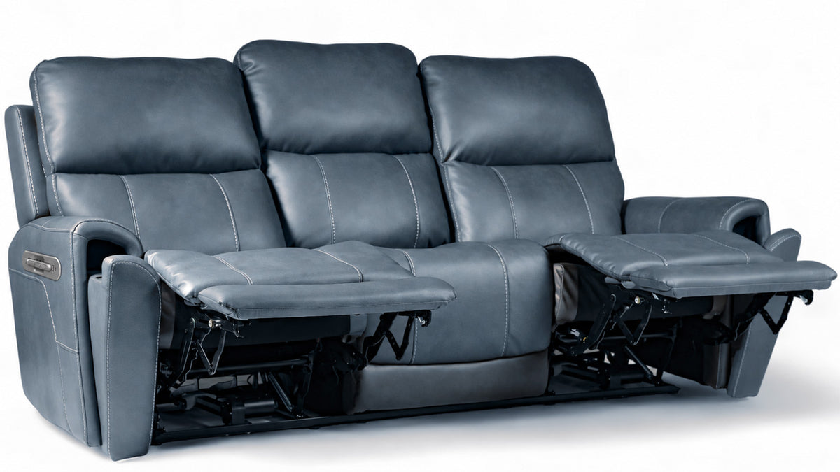 A three-seat reclining sofa in dark blue-gray leather, shown with both outer armrests extended into footrests against a plain white studio background.