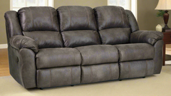 Gray reclining sofa in a room with a lamp and side table.