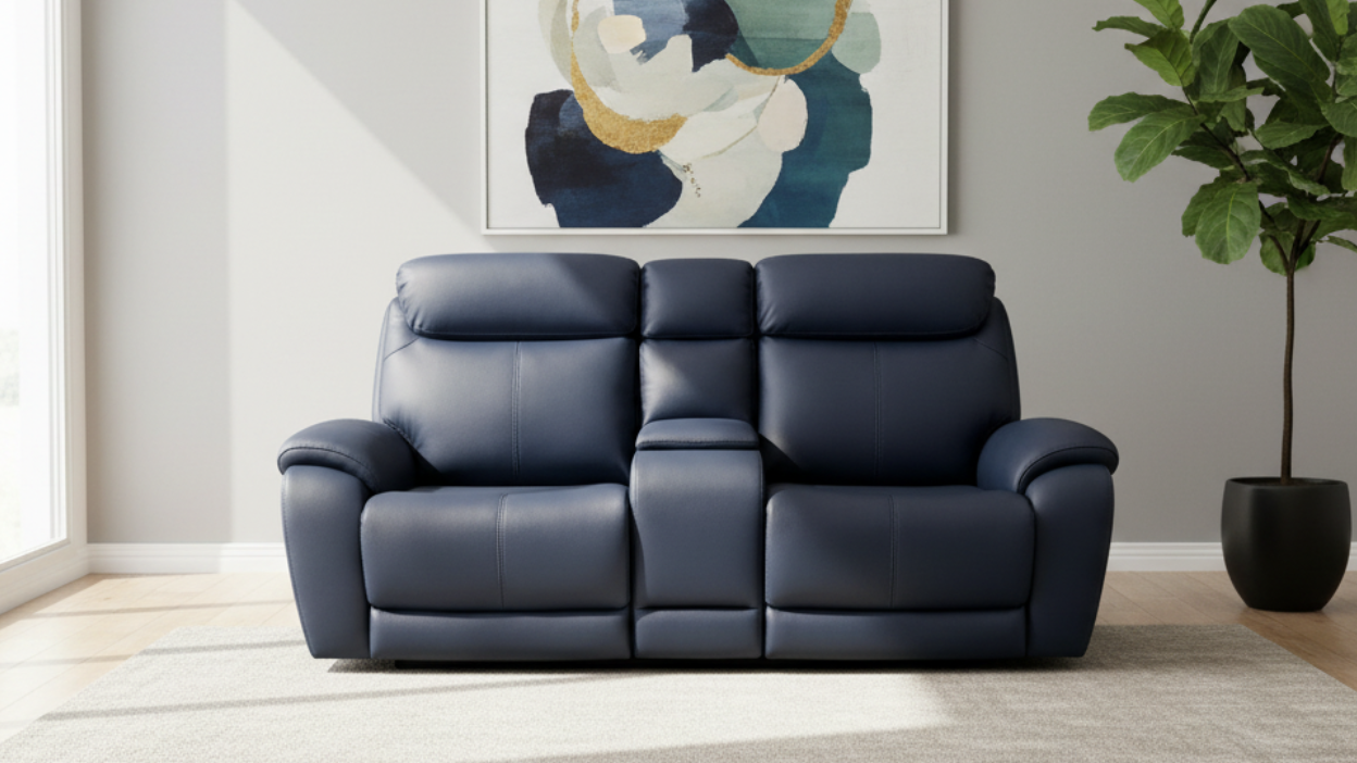 Blue leather sofa in a living room with abstract art and a plant.