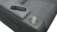 Close-up of a gray upholstered recliner chair showing the armrest with a black remote control resting on top and a circular metallic cup holder on the side.