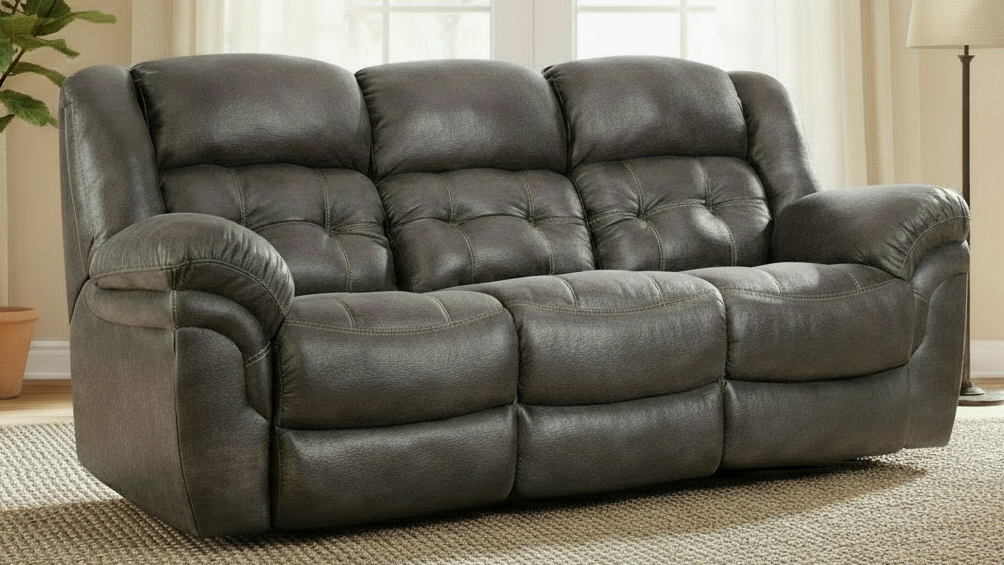Gray leather sofa in a living room setting with a lamp and plant in the background.