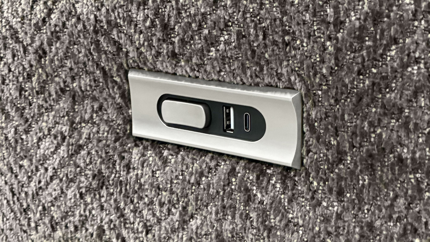 Metallic USB port cover on a textured surface