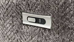 Metallic USB port cover on a textured surface