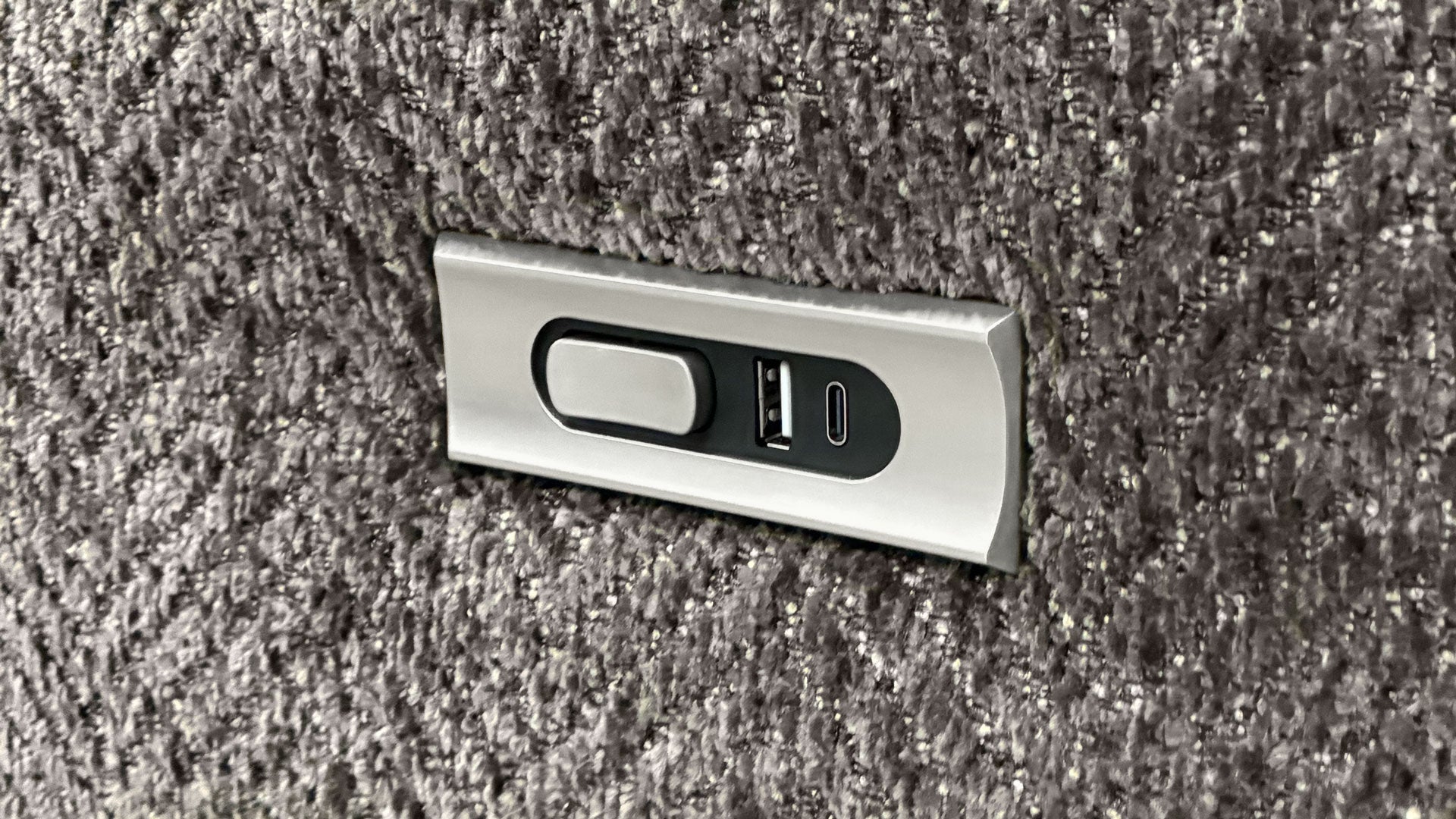 Metallic USB port cover on a textured surface